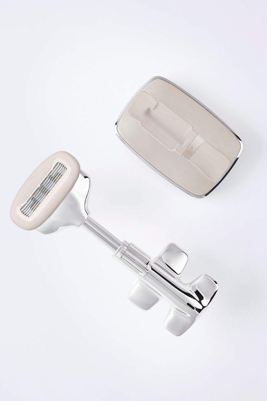 Minimalist commercial photography of Sakura Brand chrome products with high-end reflections in an all-white studio setting.