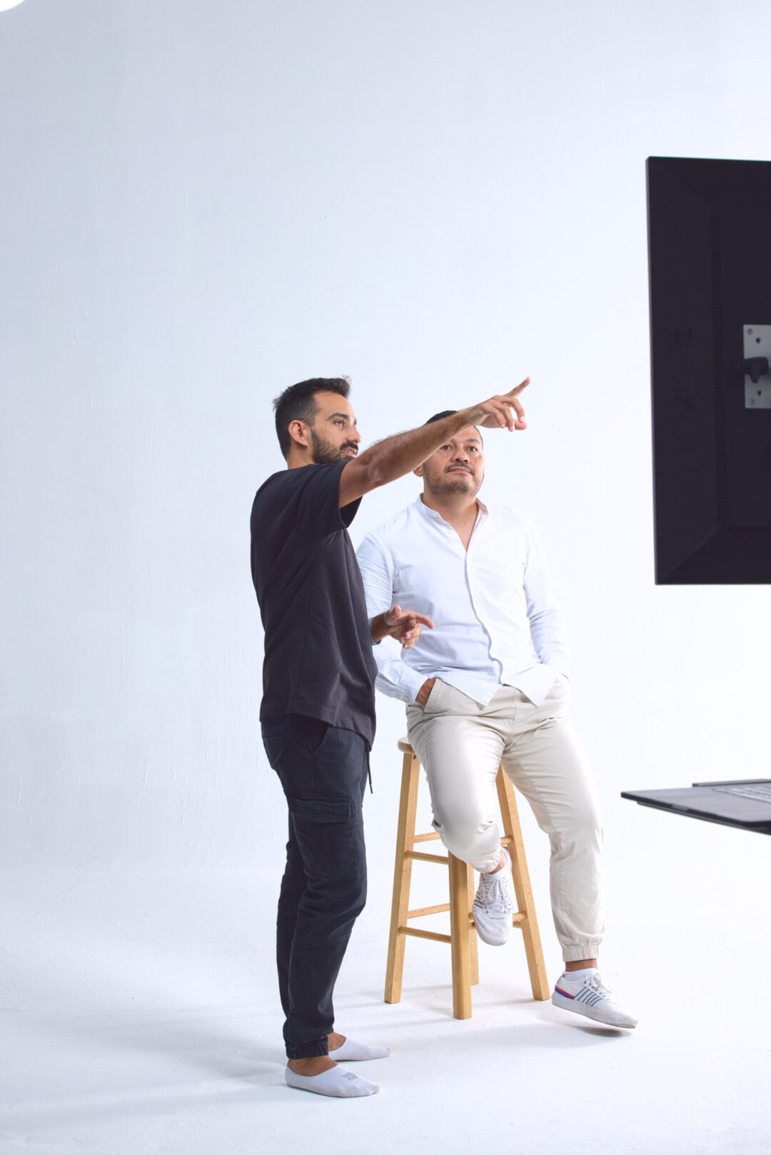 Luis Cano providing professional creative direction and posing guidance to models on a high-end commercial fashion set.